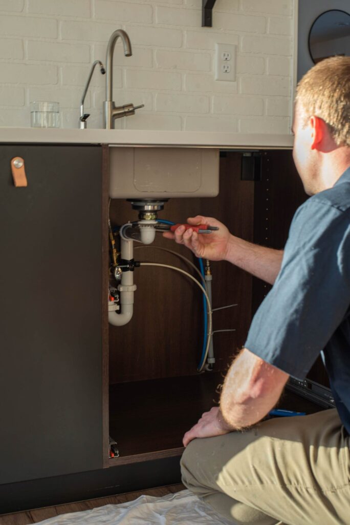 Riser Plumbing Plumber fixing the leaky pipes underneath the sink.